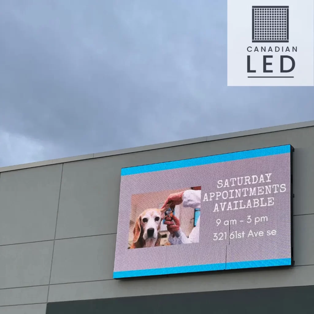 Outdoor LED screen displaying an advertisement for a veterinary clinic offering Saturday appointments.