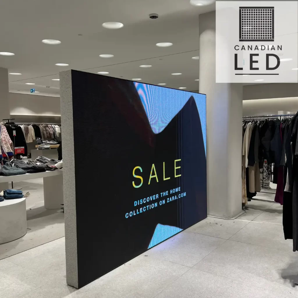 Large LED screen inside a modern retail store displaying a "SALE" advertisement with high brightness and vivid colors.