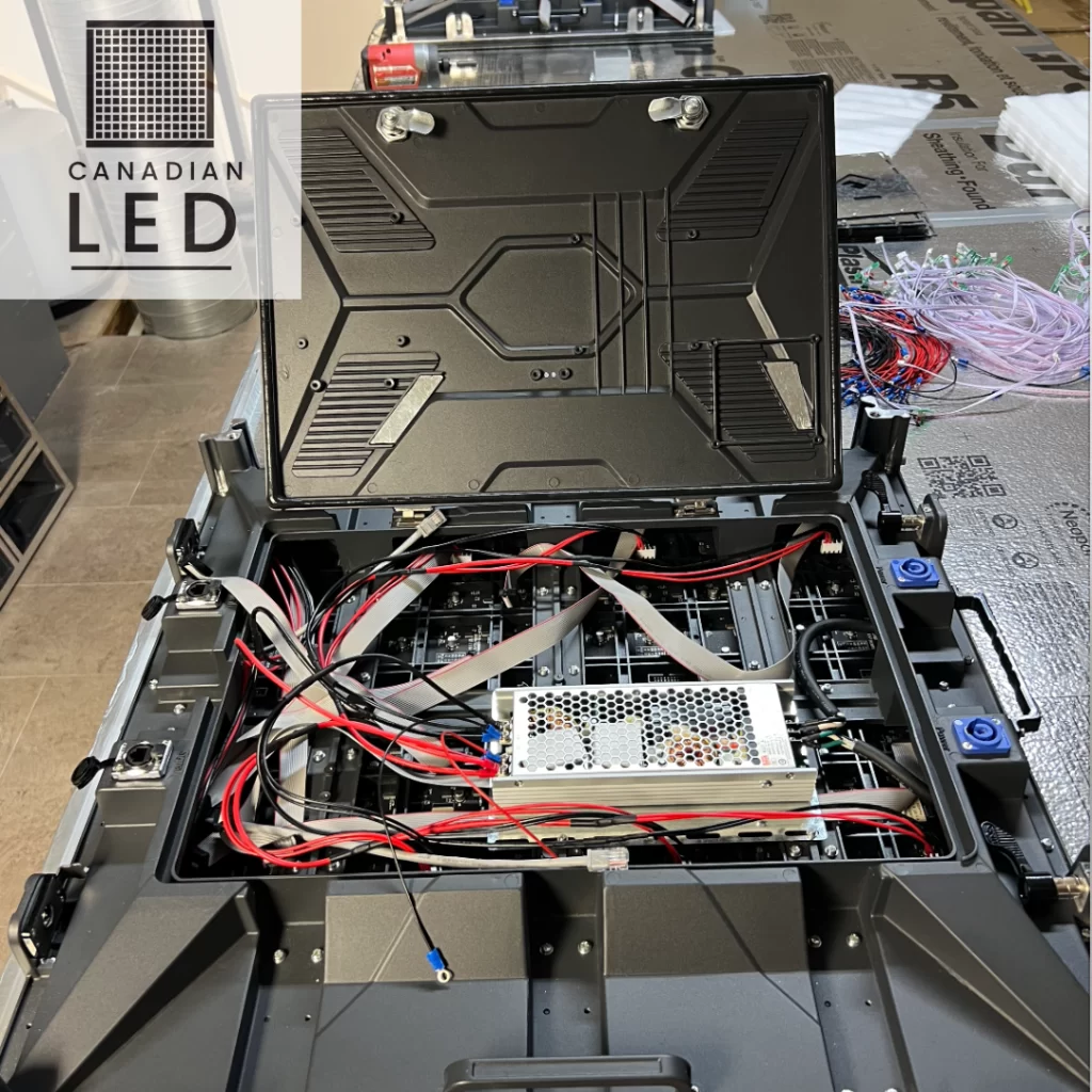 Open LED screen panel showcasing internal wiring and power components during maintenance.