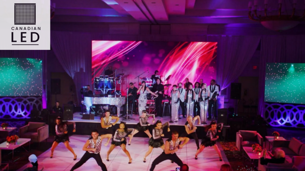 Dance performance with LED video wall backdrop and live band on stage, lit with vibrant lighting at an indoor event.