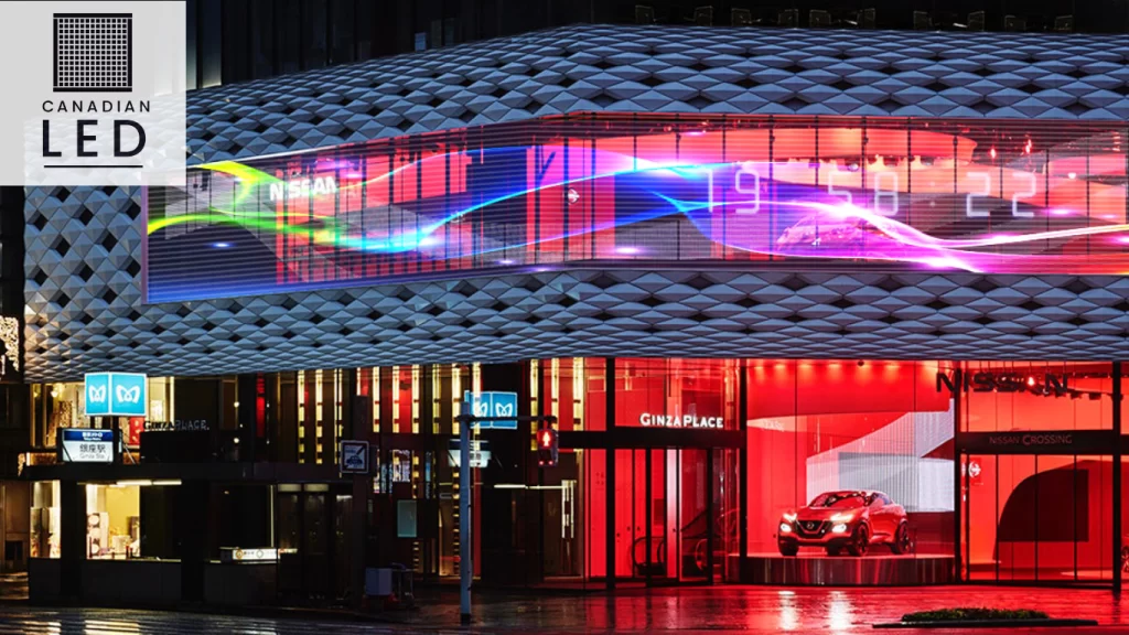 High-resolution transparent LED screen displaying vibrant visuals on the façade of a modern commercial building at night.
