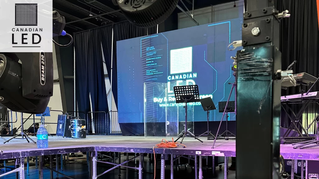 LED screen setup at an event venue with stage lighting and sound equipment, featuring Canadian LED's display with branding.