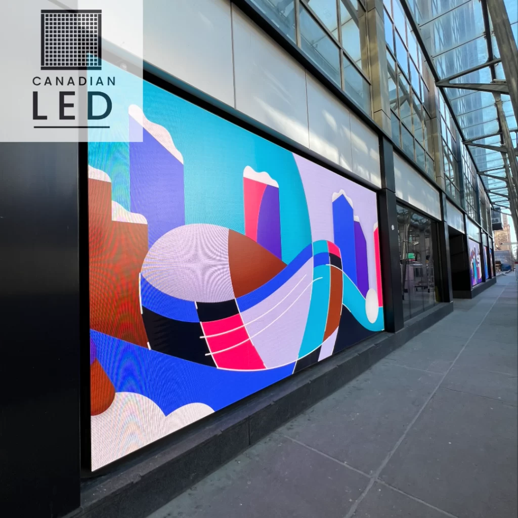 Large outdoor LED video wall displaying vibrant digital art on a modern commercial building.