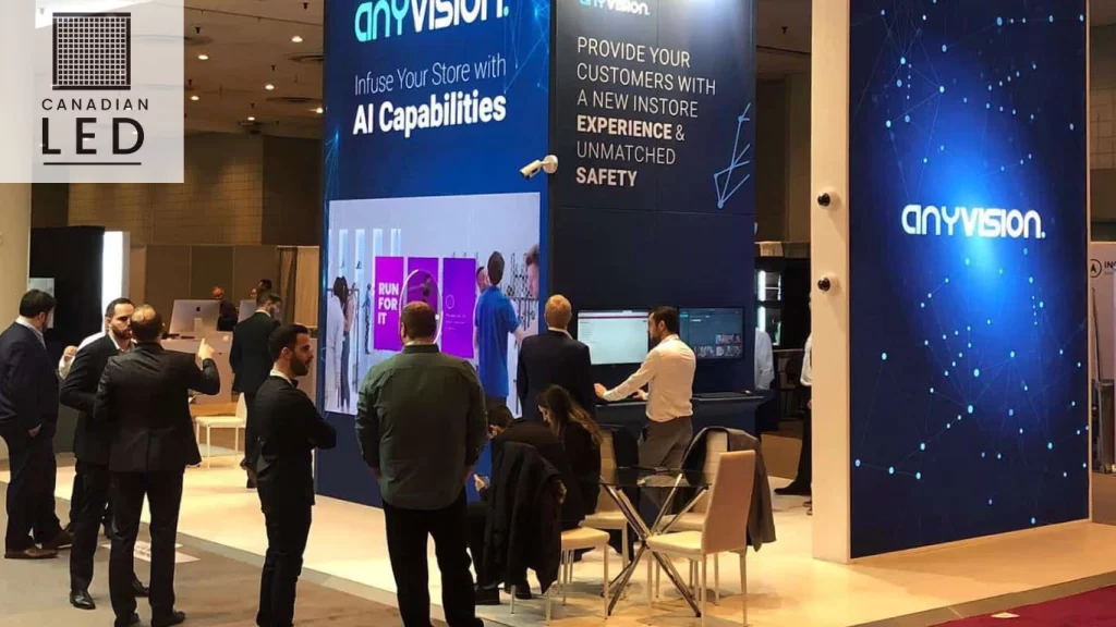 LED display booth at a tech expo showcasing AI-powered retail solutions by AnyVision with attendees engaging at the exhibit.